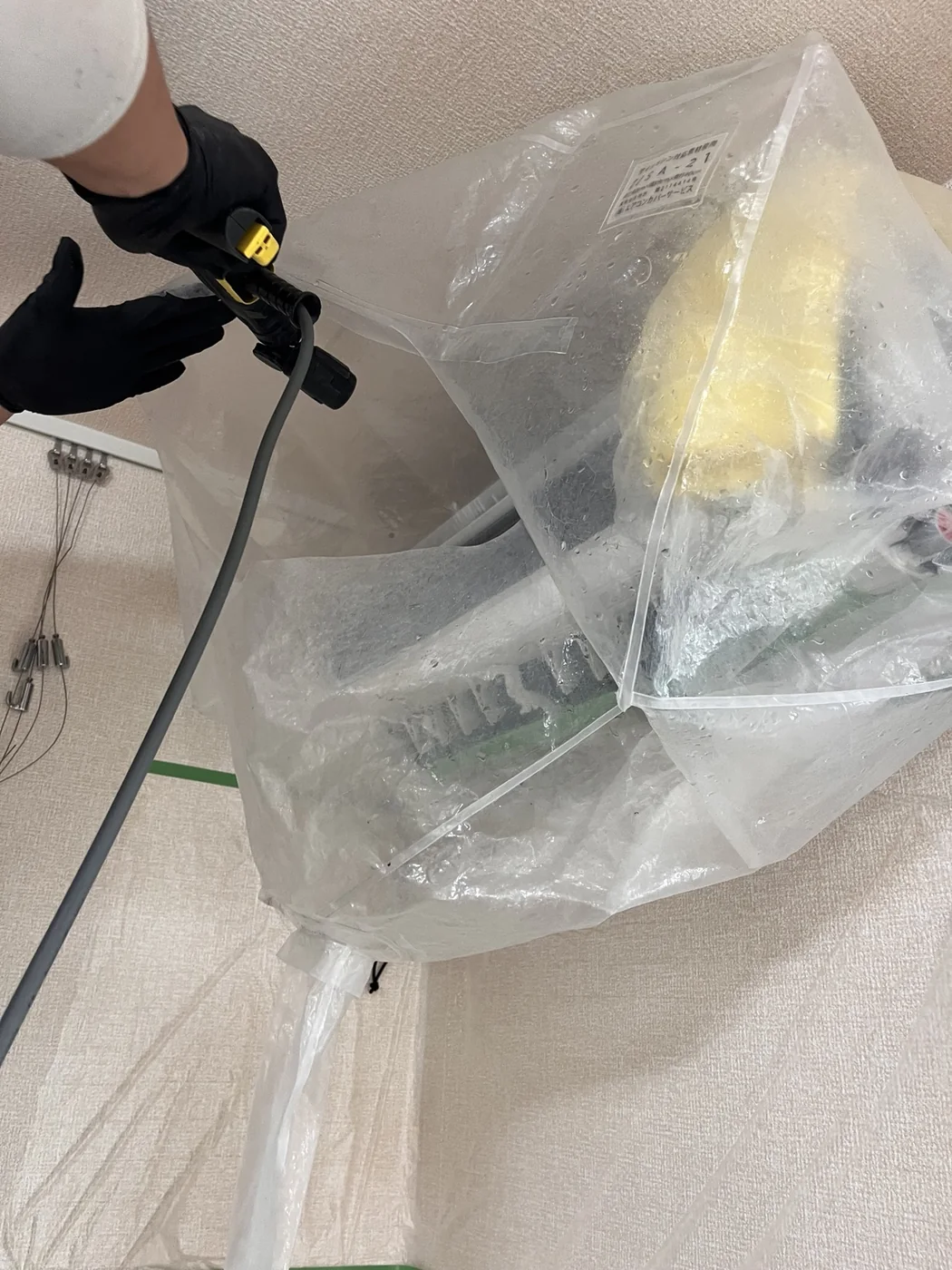 家庭用エアコン内部を高圧洗浄している様子