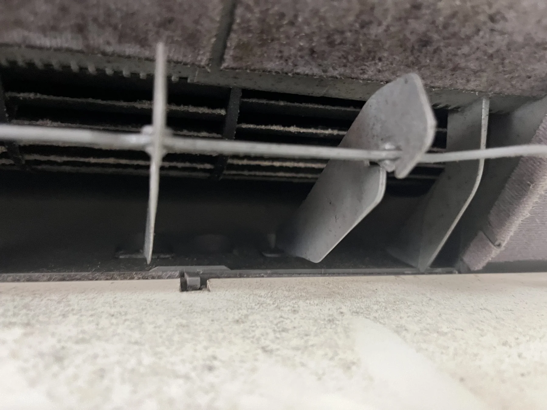 家庭用エアコンの送風口とファン周辺に黒い汚れが見える洗浄前の状態