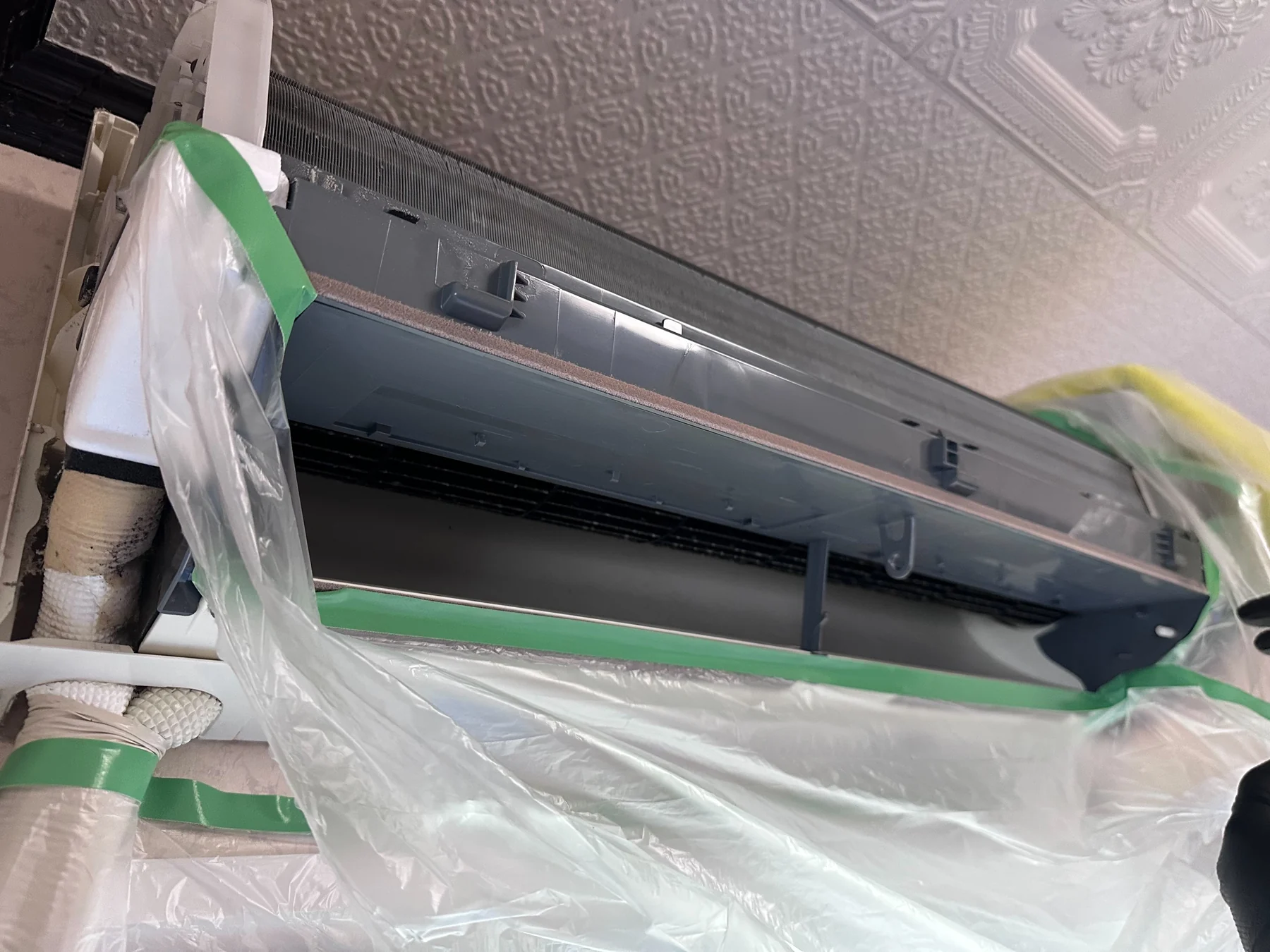 家庭用エアコン本体と周辺を洗浄前に養生した状態